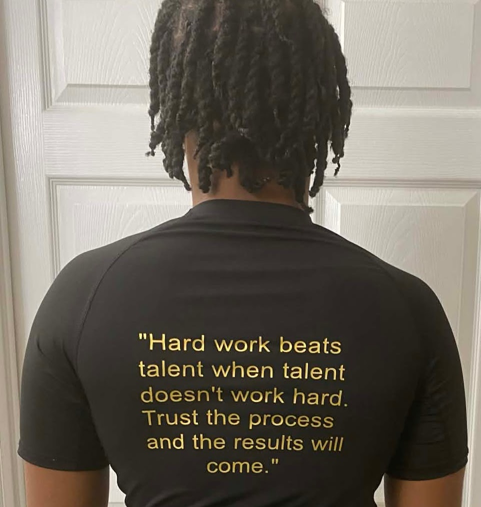 Dantae wearing the back of the DLMJ Athletics shirt